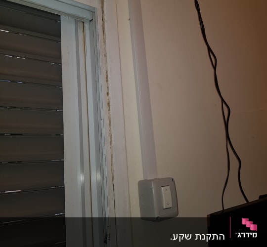 מתג חשמלי על קיר עם חוטים חשמליים